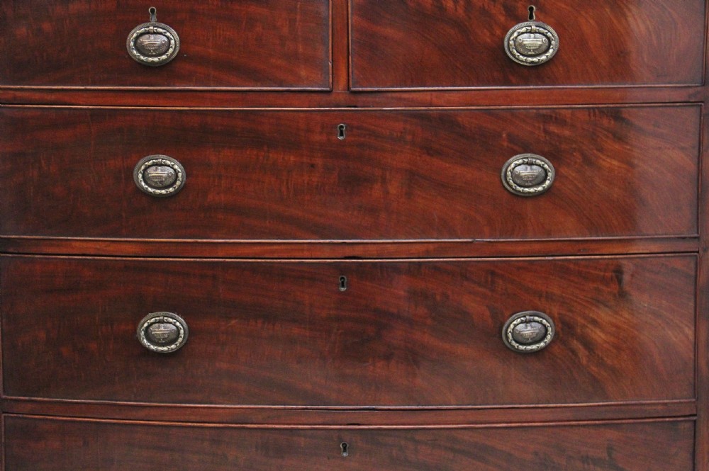 An early nineteenth-century mahogany bowfront chest of drawers featuring two short drawers over three long drawers with brass oval handles and bracket feet. View II