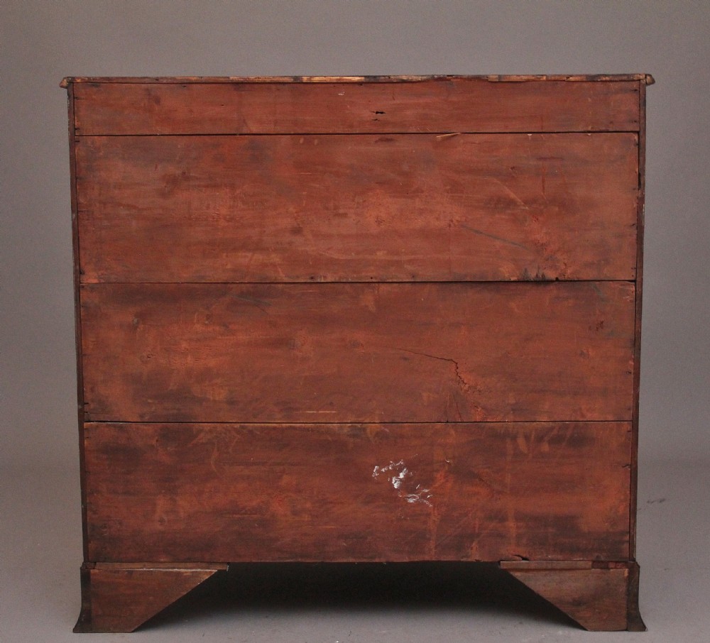An early nineteenth-century mahogany bowfront chest of drawers featuring two short drawers over three long drawers with brass oval handles and bracket feet. View VI