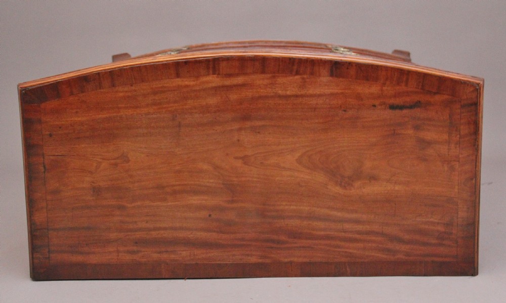 An early nineteenth-century mahogany bowfront chest of drawers featuring two short drawers over three long drawers with brass oval handles and bracket feet. View X