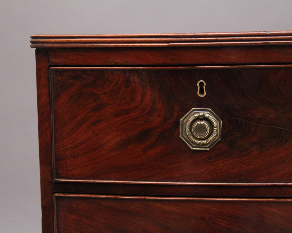 An early nineteenth-century flame mahogany bowfront chest of drawers featuring a two over two drawer configuration with brass octagonal ring handles. View III