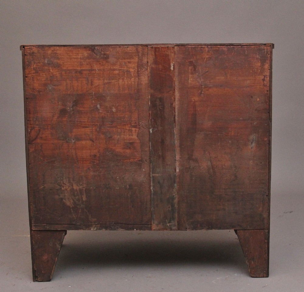 An early nineteenth-century flame mahogany bowfront chest of drawers featuring a two over two drawer configuration with brass octagonal ring handles. View IX