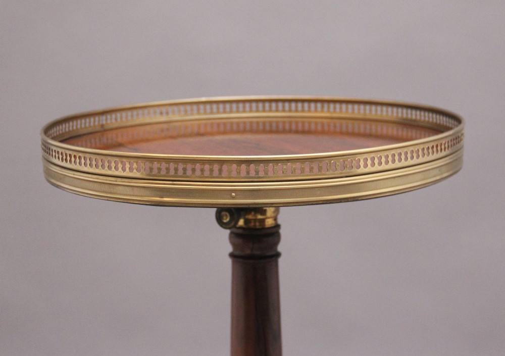 A 19th-century dark rosewood telescopic occasional table with a circular top featuring a brass gallery rim, a turned pedestal column, and a triform base on brass claw feet. View V