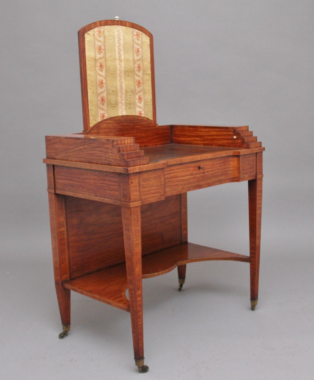 A 19th-century satinwood ladies writing table featuring a stepped side gallery, single frieze drawer, tapered square legs on brass castors, and a lower undertier. View VI