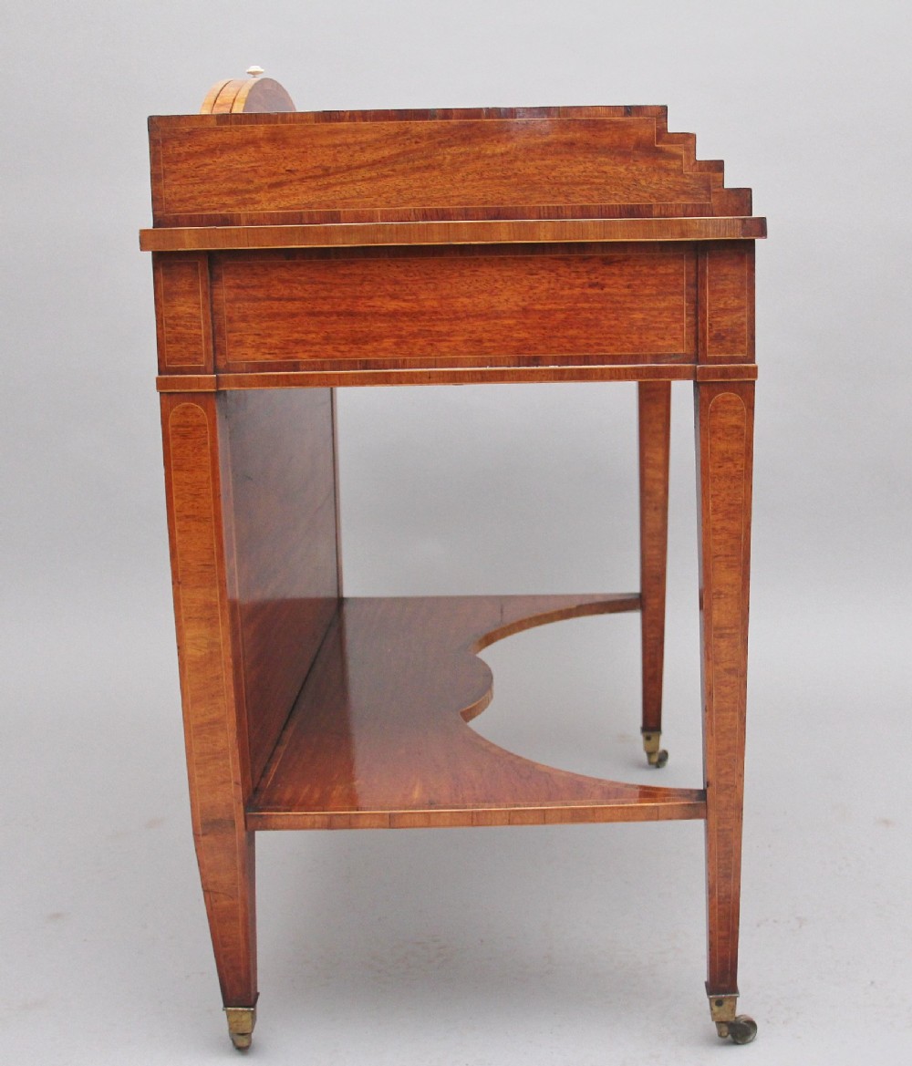 A 19th-century satinwood ladies writing table featuring a stepped side gallery, single frieze drawer, tapered square legs on brass castors, and a lower undertier. View VIII
