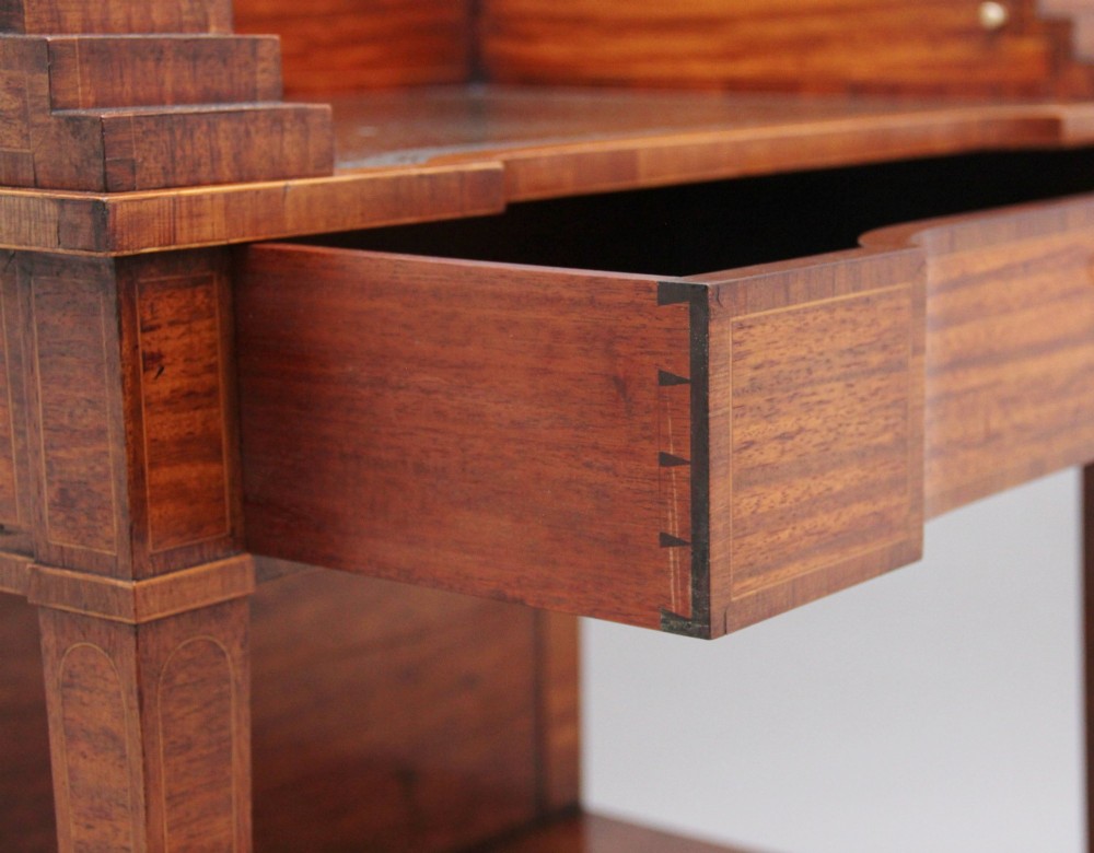 A 19th-century satinwood ladies writing table featuring a stepped side gallery, single frieze drawer, tapered square legs on brass castors, and a lower undertier. View XI