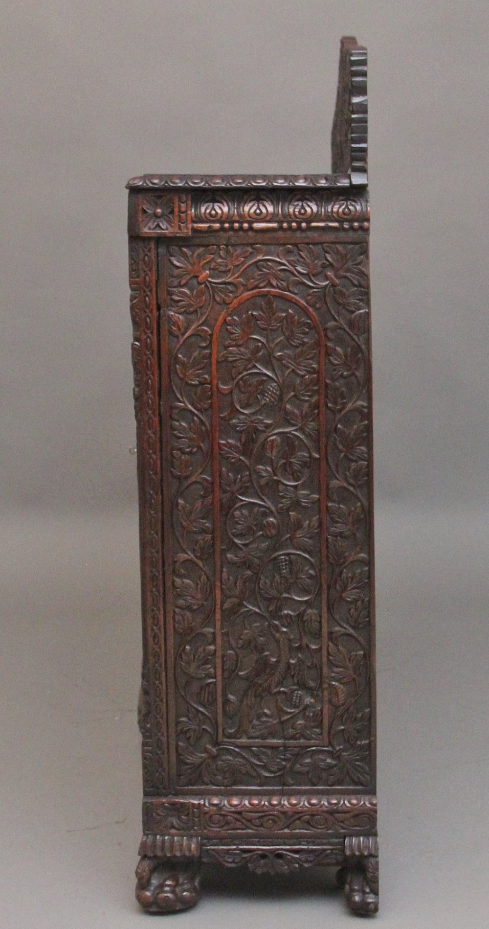 A 19th-century Anglo-Indian dark wood cabinet featuring elaborate pierced foliage carvings, four cupboard doors, and a decorative carved gallery back. View IX