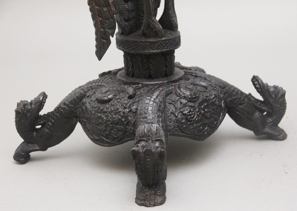 A pair of 19th-century Anglo-Indian carved hardwood torcheres featuring detailed cobra and mythical bird motifs topped with lotus platforms. View VI