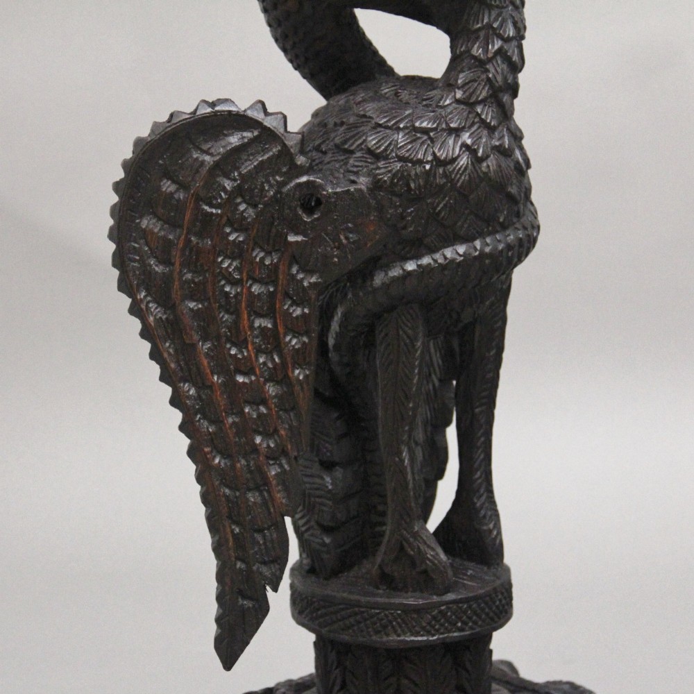 A pair of 19th-century Anglo-Indian carved hardwood torcheres featuring detailed cobra and mythical bird motifs topped with lotus platforms. View XIII