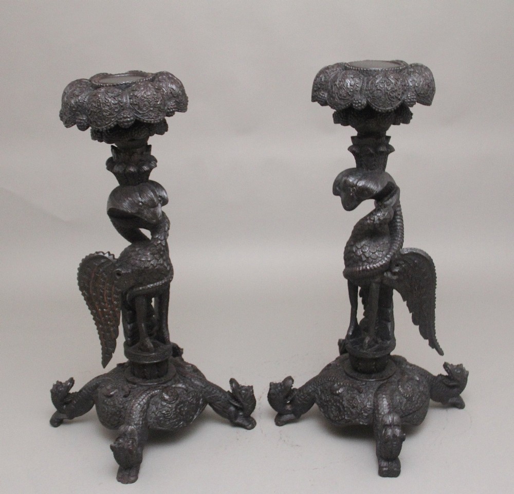 A pair of 19th-century Anglo-Indian carved hardwood torcheres featuring detailed cobra and mythical bird motifs topped with lotus platforms. View XIV