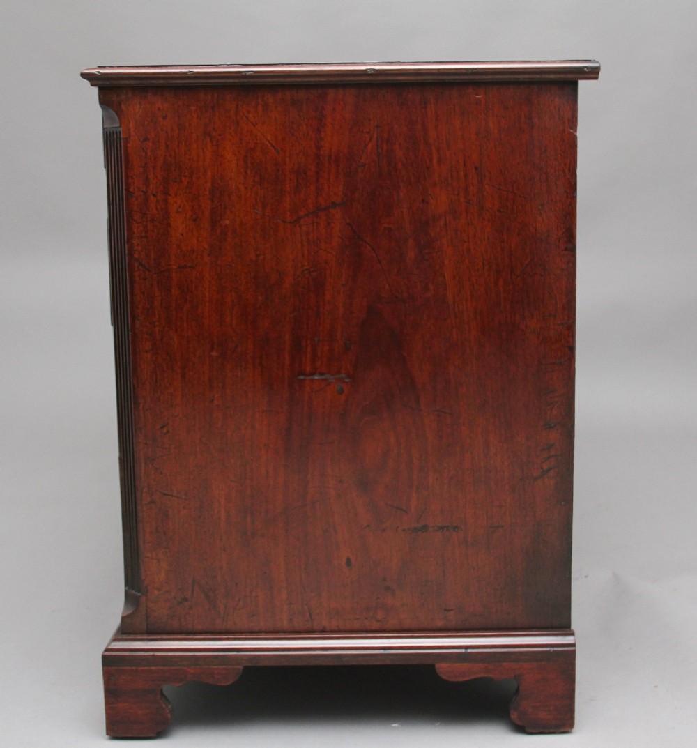 An 18th-century mahogany kneehole desk featuring a central recessed cupboard, multiple drawers with brass swan-neck handles, and bracket feet. View IX
