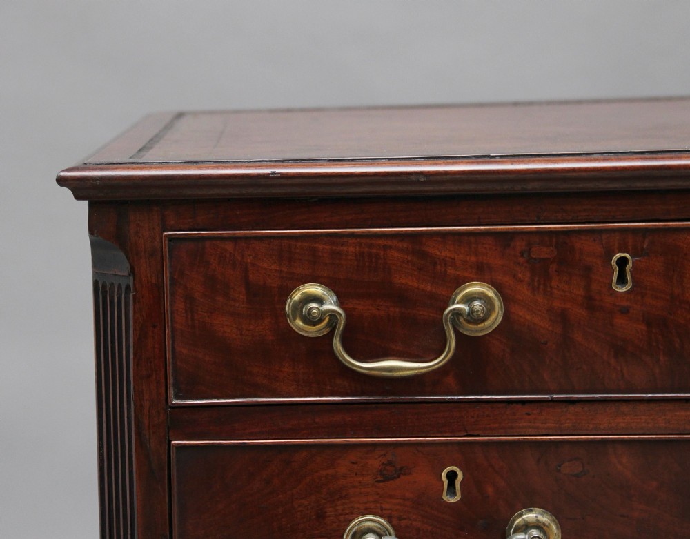An 18th-century mahogany kneehole desk featuring a central recessed cupboard, multiple drawers with brass swan-neck handles, and bracket feet. View XI