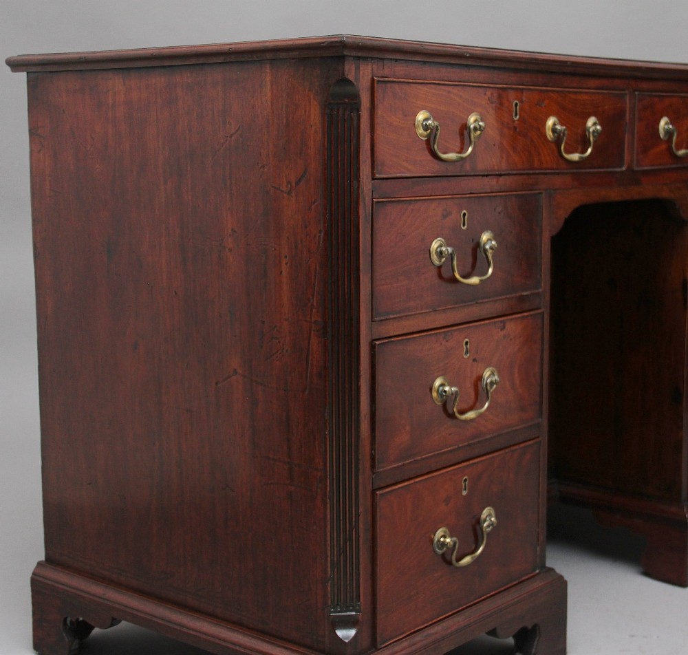 An 18th-century mahogany kneehole desk featuring a central recessed cupboard, multiple drawers with brass swan-neck handles, and bracket feet. View XIII