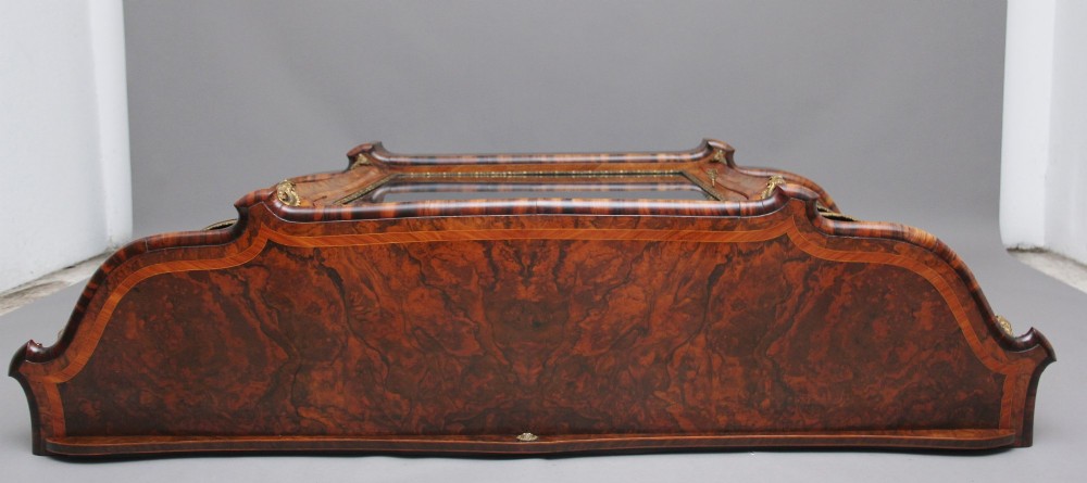 A 19th-century burr walnut credenza featuring a central glazed door, flanking curved open display shelves, and gilt ormolu mounts. View VI