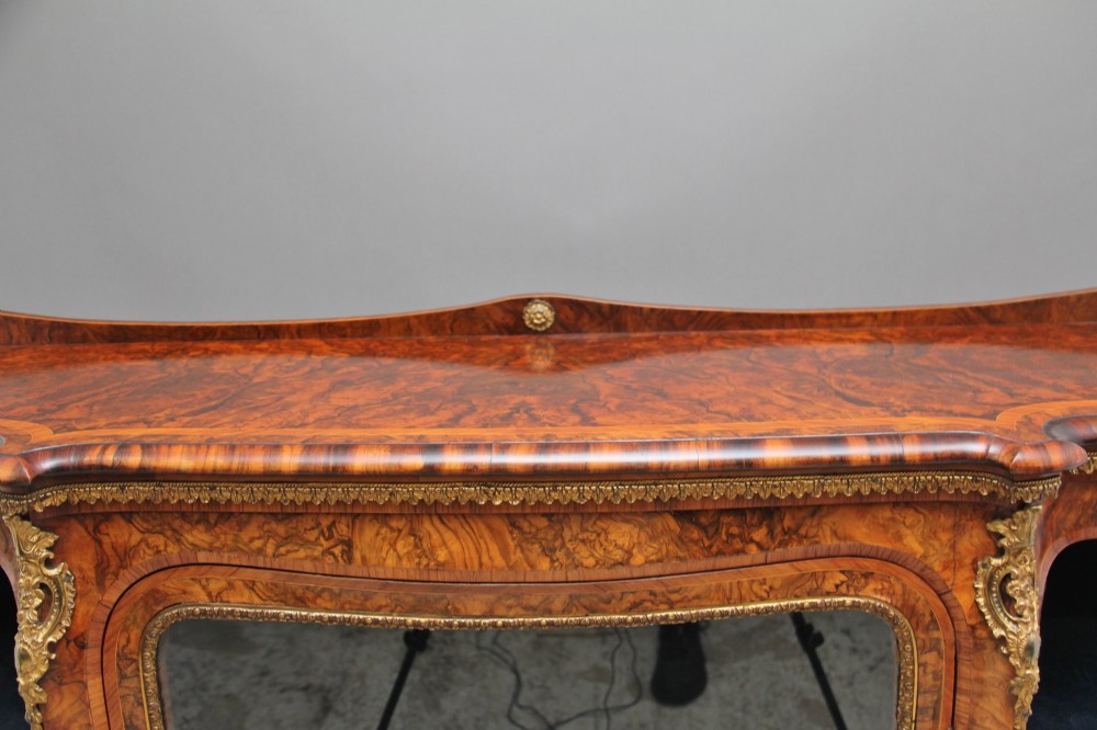 A 19th-century burr walnut credenza featuring a central glazed door, flanking curved open display shelves, and gilt ormolu mounts. View XIII