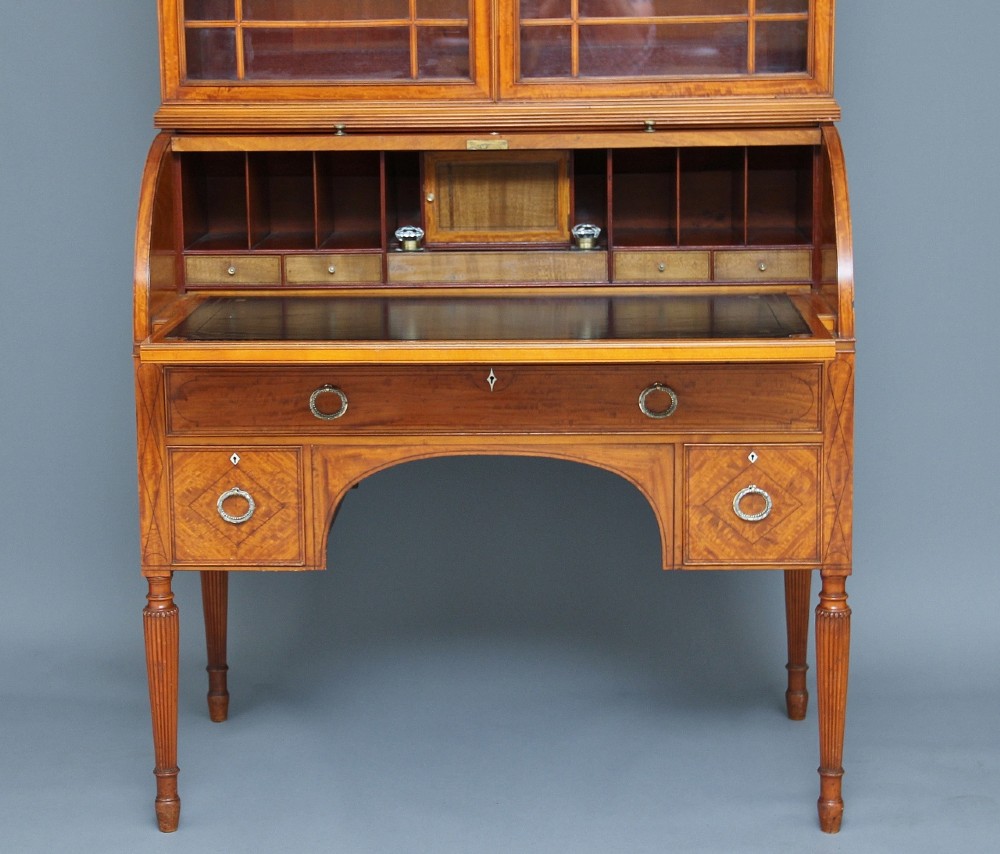 A 19th-century satinwood bureau bookcase featuring a two-door glazed upper section, a cylinder roll-top writing section, lower drawers with ring handles, and turned legs. View III