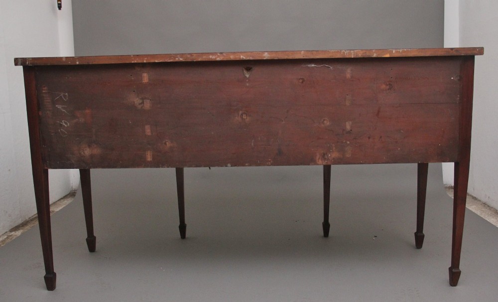 A nineteenth-century mahogany bowfront sideboard featuring inlaid crossbanding, multiple drawers with brass lion-mask ring handles, and tapered square legs. View X