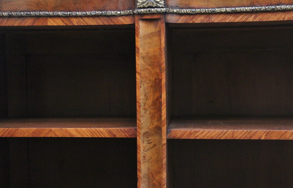 A nineteenth-century low open bookcase crafted from warm walnut wood featuring three sections with adjustable shelving and decorative gilt-bronze ormolu mounts along the borders. View III