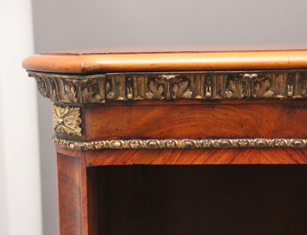 A nineteenth-century low open bookcase crafted from warm walnut wood featuring three sections with adjustable shelving and decorative gilt-bronze ormolu mounts along the borders. View VII