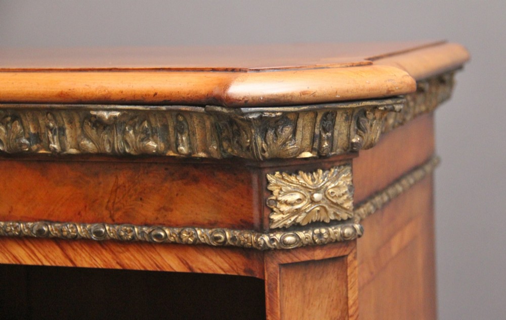 A nineteenth-century low open bookcase crafted from warm walnut wood featuring three sections with adjustable shelving and decorative gilt-bronze ormolu mounts along the borders. View VIII