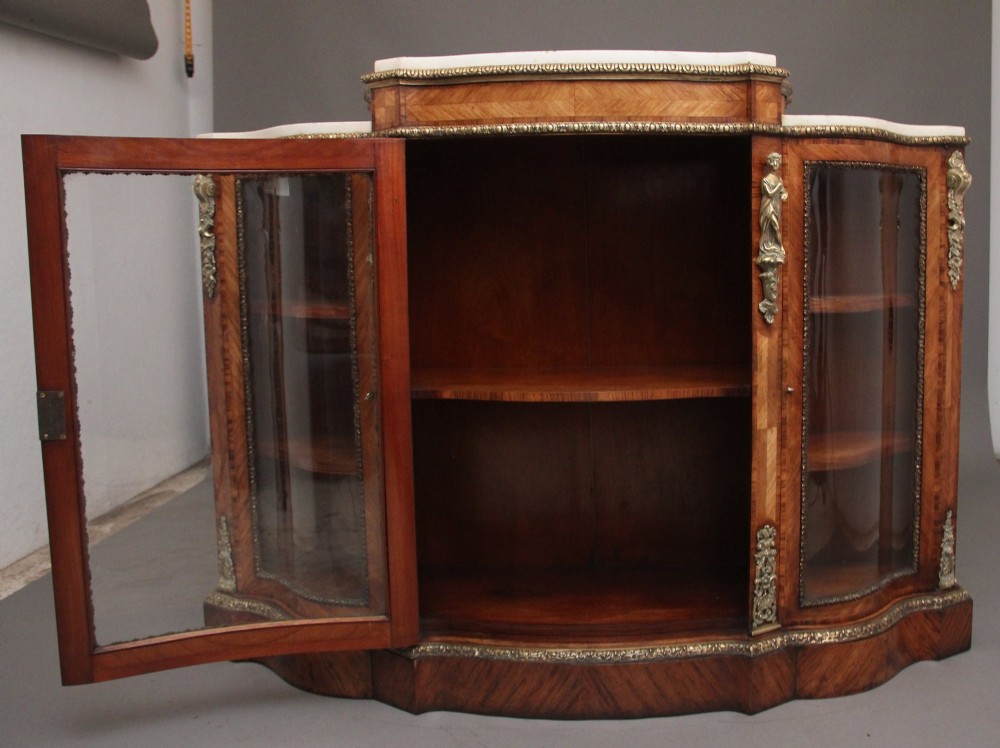 A 19th-century French kingwood credenza featuring a stepped white marble top, three glazed doors, parquetry veneer, and cast gilt-bronze caryatid mounts. View II