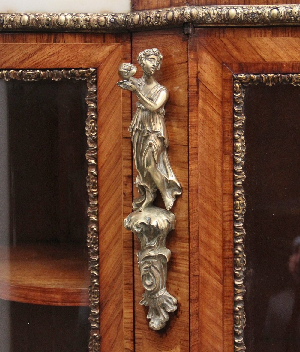 A 19th-century French kingwood credenza featuring a stepped white marble top, three glazed doors, parquetry veneer, and cast gilt-bronze caryatid mounts. View XI