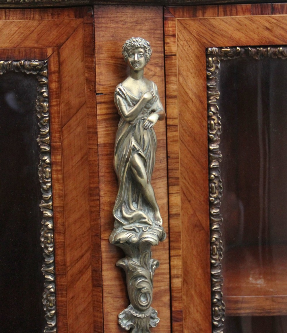 A 19th-century French kingwood credenza featuring a stepped white marble top, three glazed doors, parquetry veneer, and cast gilt-bronze caryatid mounts. View XV