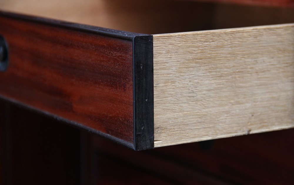 An early nineteenth-century mahogany cabinet on stand featuring flame-veneered panelled double doors above a drawer, supported by turned reeded legs. View XI