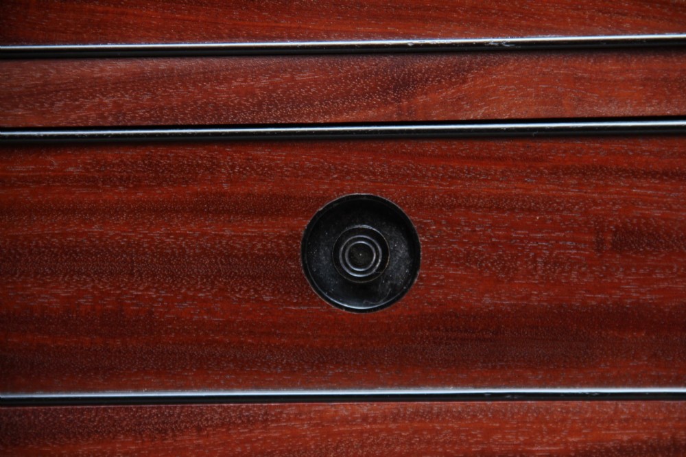 An early nineteenth-century mahogany cabinet on stand featuring flame-veneered panelled double doors above a drawer, supported by turned reeded legs. View XV