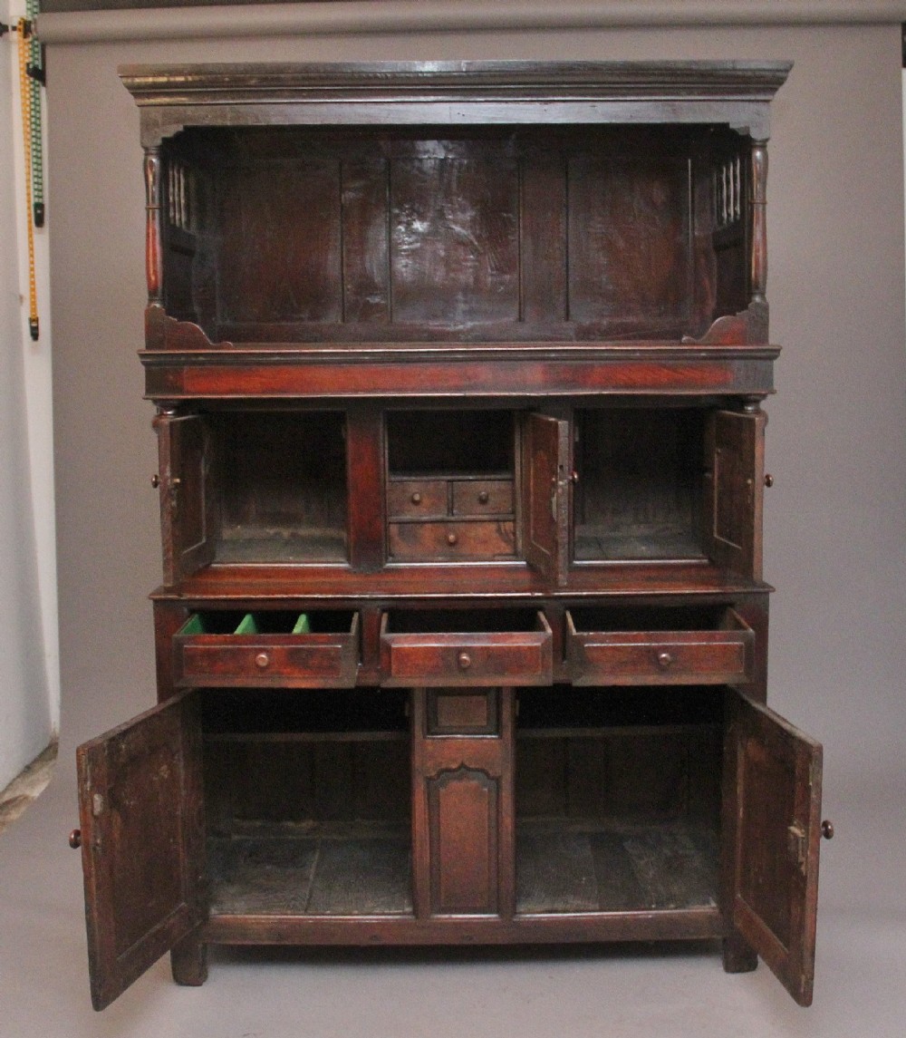 An early eighteenth-century dark Welsh oak tridarn featuring a three-tier design with an open top canopy, middle cupboards with arched panels, and a lower section with drawers and doors. View III