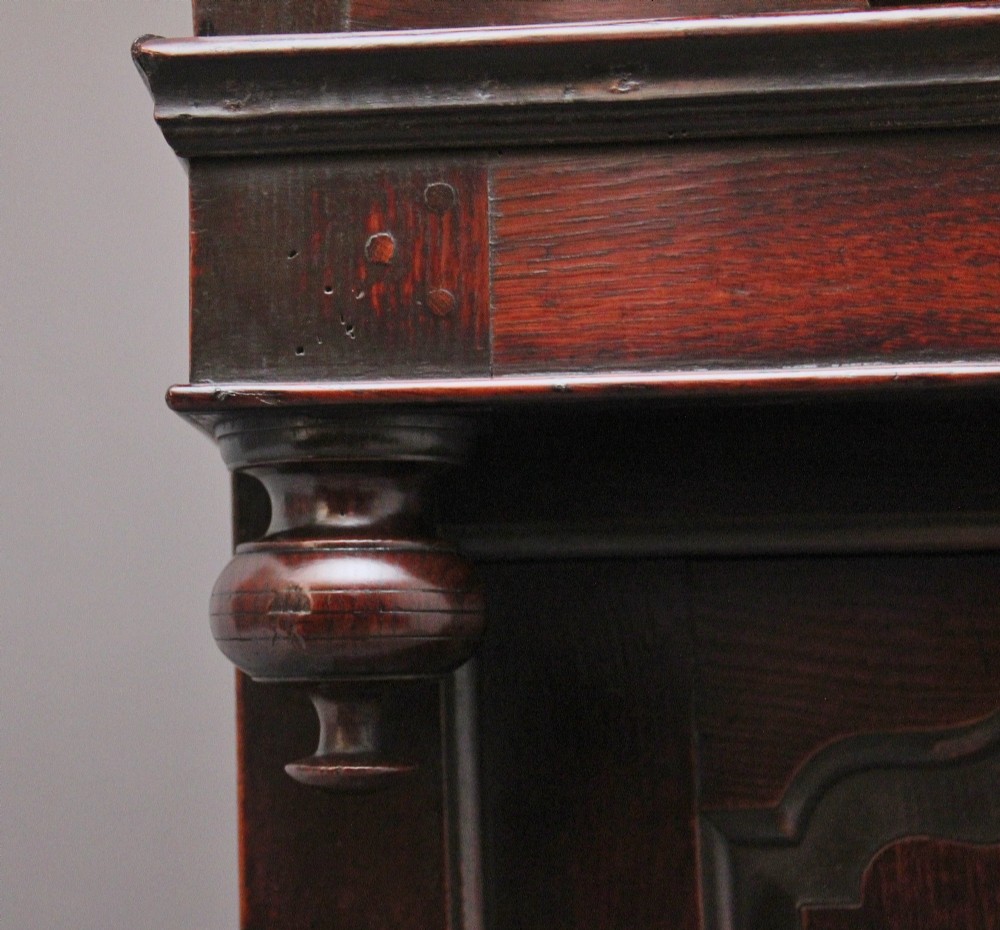 An early eighteenth-century dark Welsh oak tridarn featuring a three-tier design with an open top canopy, middle cupboards with arched panels, and a lower section with drawers and doors. View XII