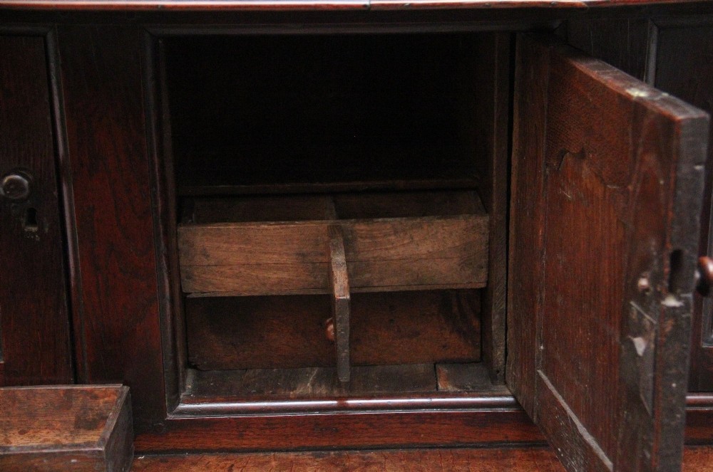 An early eighteenth-century dark Welsh oak tridarn featuring a three-tier design with an open top canopy, middle cupboards with arched panels, and a lower section with drawers and doors. View XV