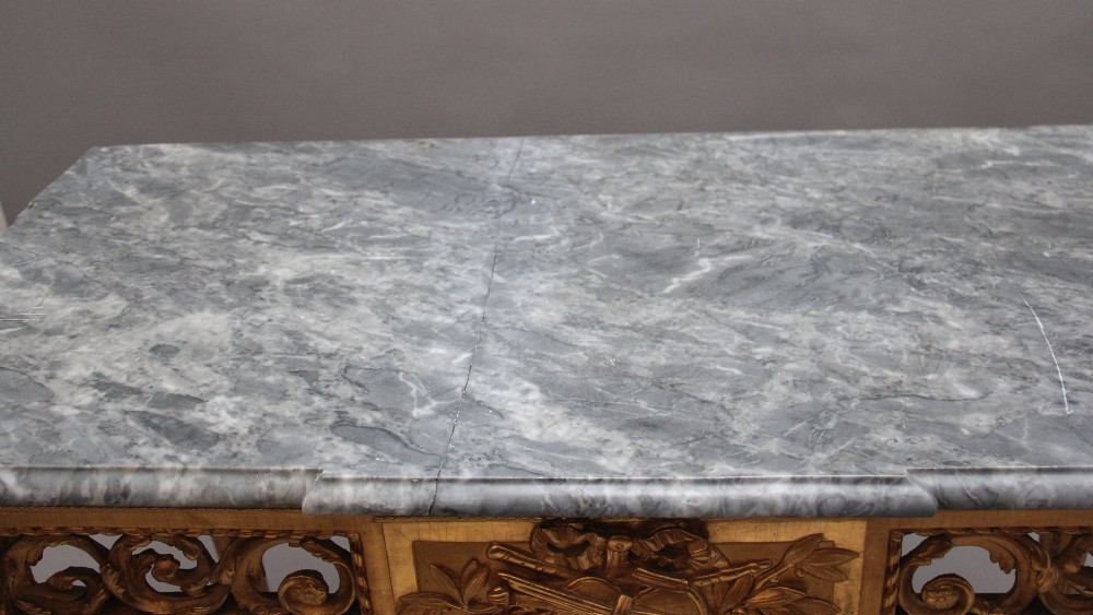 An 18th century Italian giltwood console table featuring an intricate carved frieze, fluted tapered legs, and a grey marble top. View XII