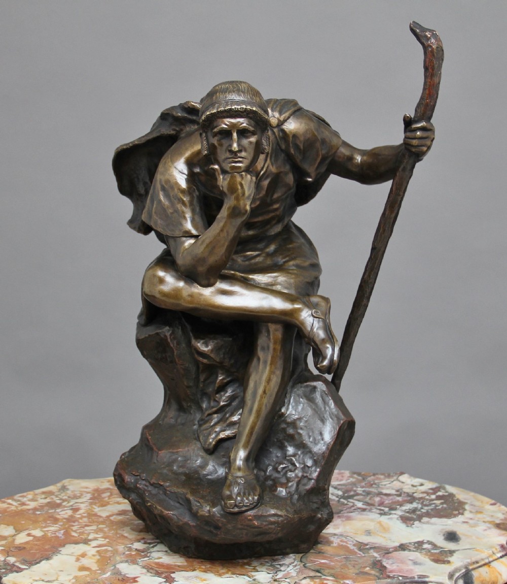 A 19th-century patinated bronze sculpture depicting the mythological figure Oedipus seated on a rock in contemplation while holding a staff. View II
