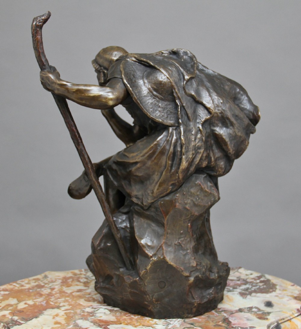 A 19th-century patinated bronze sculpture depicting the mythological figure Oedipus seated on a rock in contemplation while holding a staff. View V