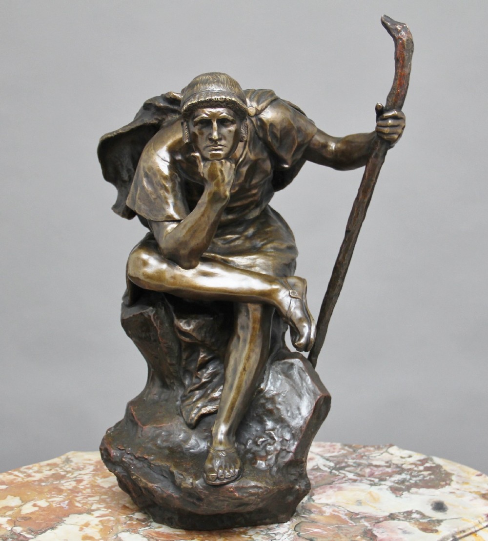 A 19th-century patinated bronze sculpture depicting the mythological figure Oedipus seated on a rock in contemplation while holding a staff. View VII
