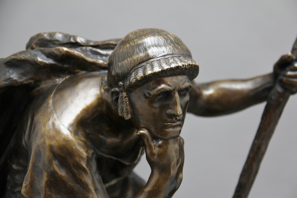 A 19th-century patinated bronze sculpture depicting the mythological figure Oedipus seated on a rock in contemplation while holding a staff. View VIII