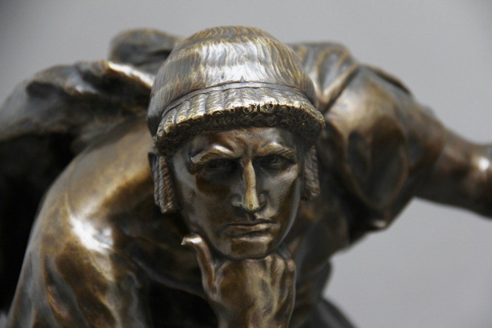 A 19th-century patinated bronze sculpture depicting the mythological figure Oedipus seated on a rock in contemplation while holding a staff. View IX
