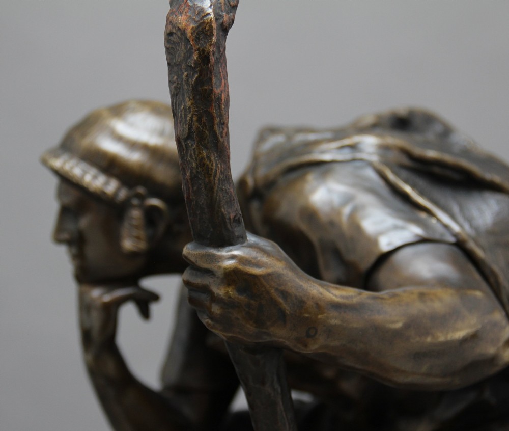 A 19th-century patinated bronze sculpture depicting the mythological figure Oedipus seated on a rock in contemplation while holding a staff. View X