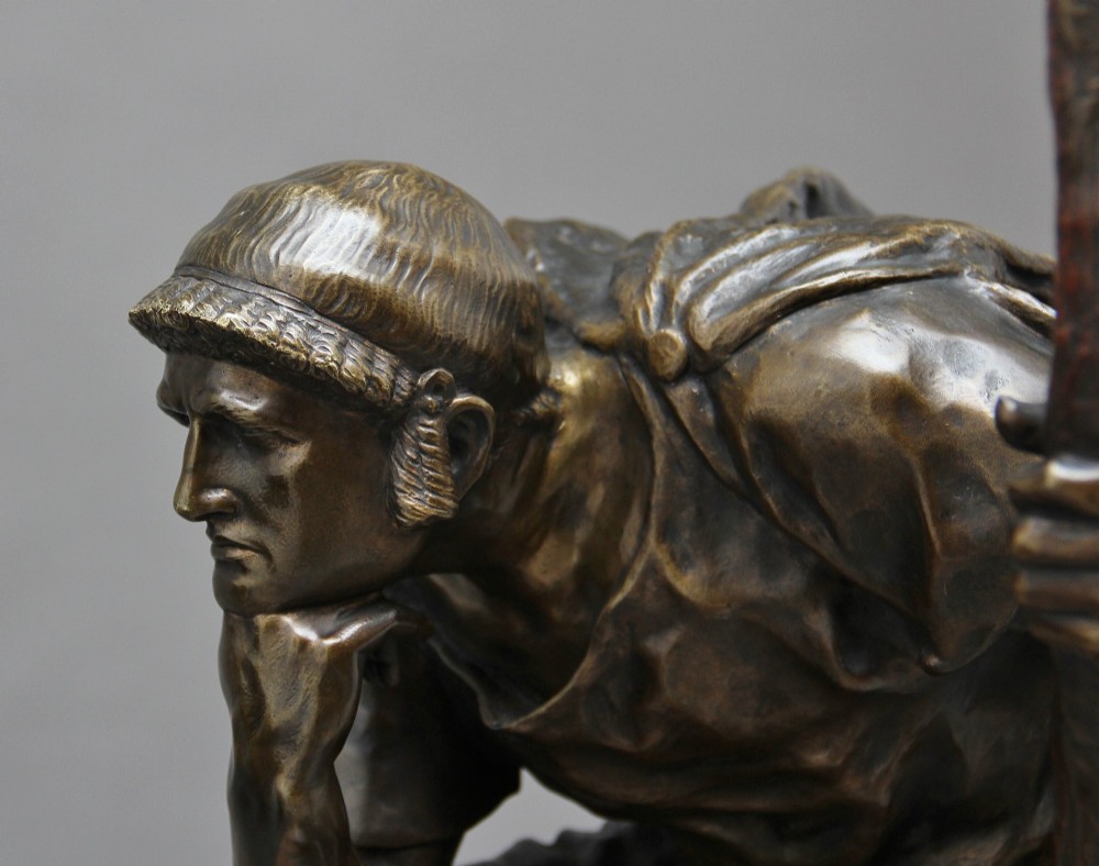 A 19th-century patinated bronze sculpture depicting the mythological figure Oedipus seated on a rock in contemplation while holding a staff. View XI