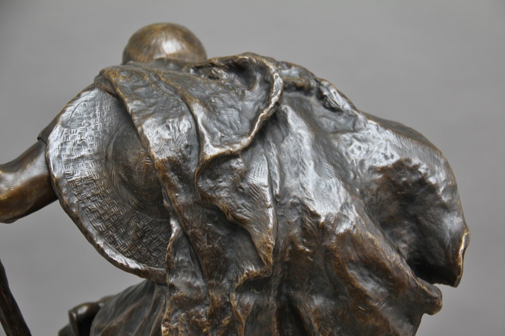 A 19th-century patinated bronze sculpture depicting the mythological figure Oedipus seated on a rock in contemplation while holding a staff. View XIII