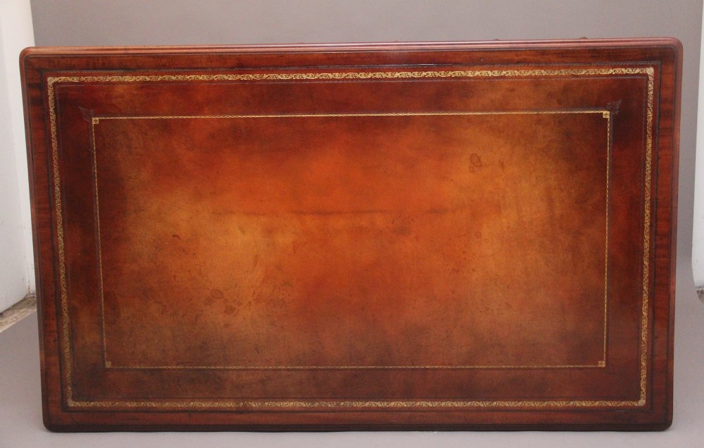 A 19th-century mahogany partners writing table featuring three drawers with turned wooden knobs, an inset leather surface, and four turned legs on brass castors. View IX