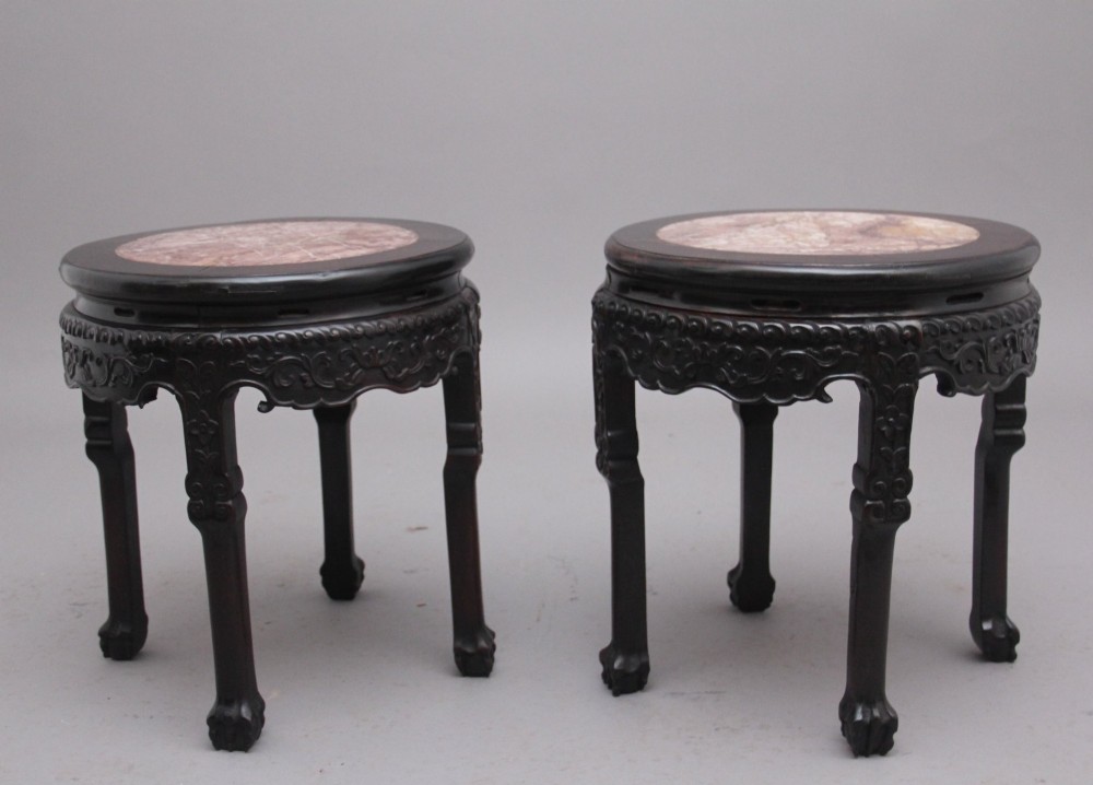 A pair of 19th-century Chinese carved dark hardwood circular occasional tables with inset pink marble tops and carved legs. View II