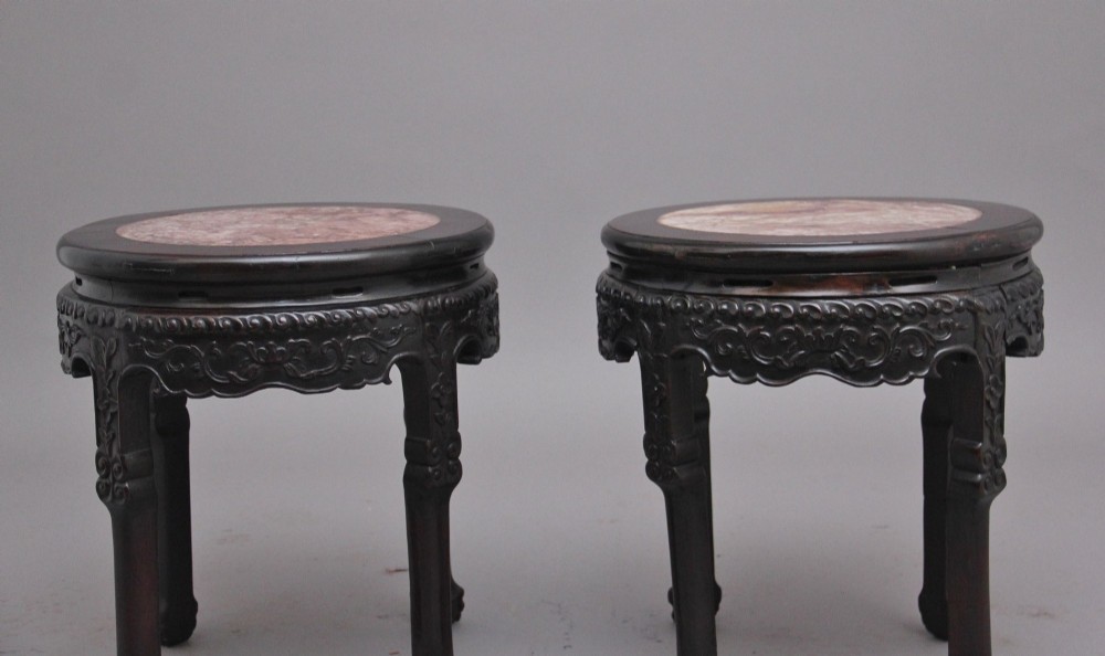 A pair of 19th-century Chinese carved dark hardwood circular occasional tables with inset pink marble tops and carved legs. View IX