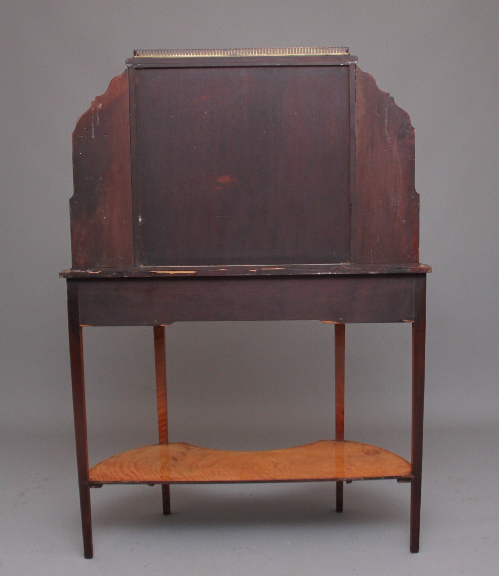 A 19th-century satinwood display cabinet featuring central glazed double doors, curved side shelves, a marquetry-inlaid drawer, and slender tapered legs with a lower undertier. View XI