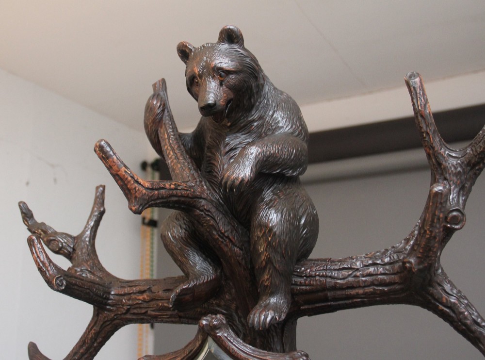 A 19th-century hand-carved Black Forest hall stand featuring two carved bear figures, branch-form coat hooks, small mirrors, and an umbrella ring base. View II