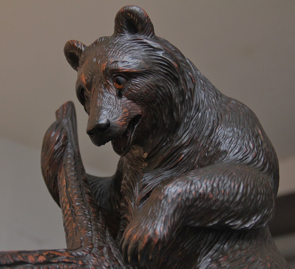A 19th-century hand-carved Black Forest hall stand featuring two carved bear figures, branch-form coat hooks, small mirrors, and an umbrella ring base. View V