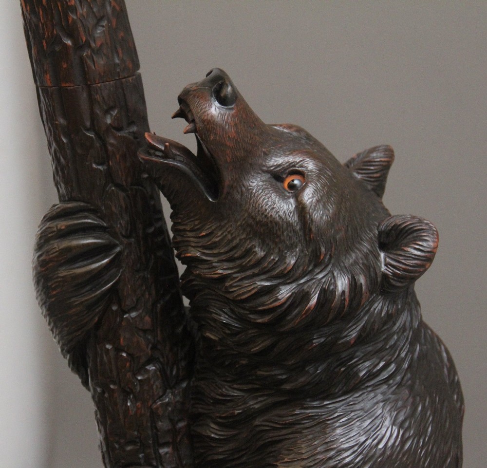 A 19th-century hand-carved Black Forest hall stand featuring two carved bear figures, branch-form coat hooks, small mirrors, and an umbrella ring base. View VII