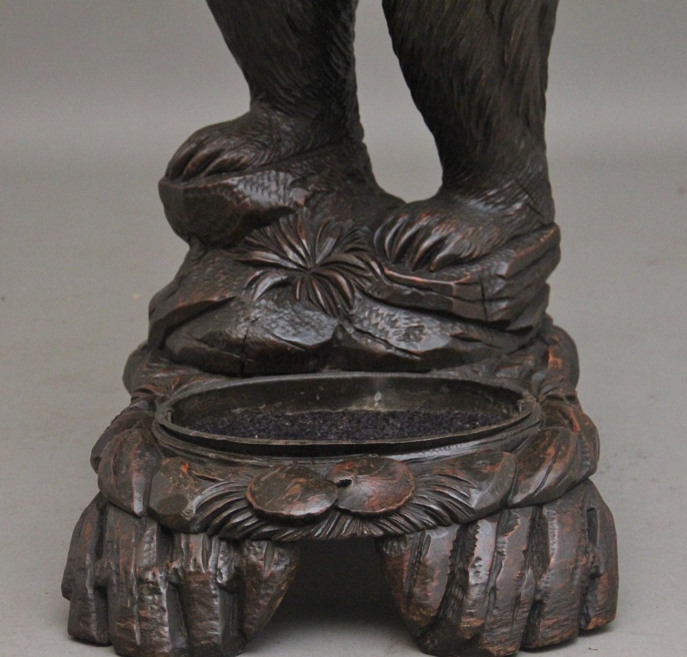A 19th-century hand-carved Black Forest hall stand featuring two carved bear figures, branch-form coat hooks, small mirrors, and an umbrella ring base. View XI