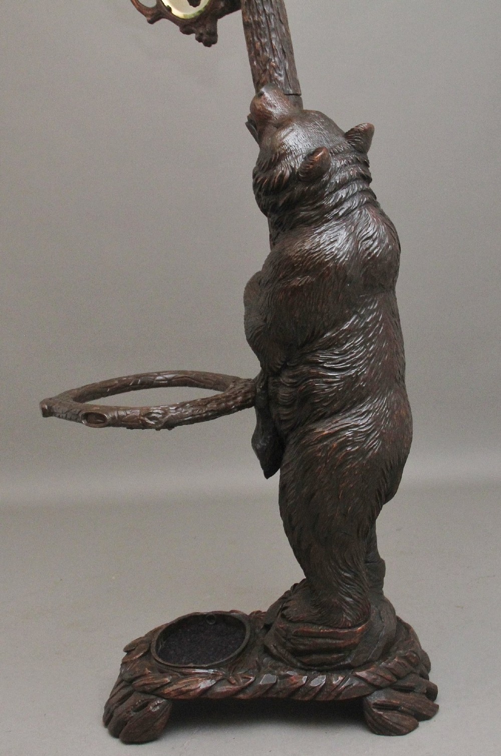 A 19th-century hand-carved Black Forest hall stand featuring two carved bear figures, branch-form coat hooks, small mirrors, and an umbrella ring base. View XIII