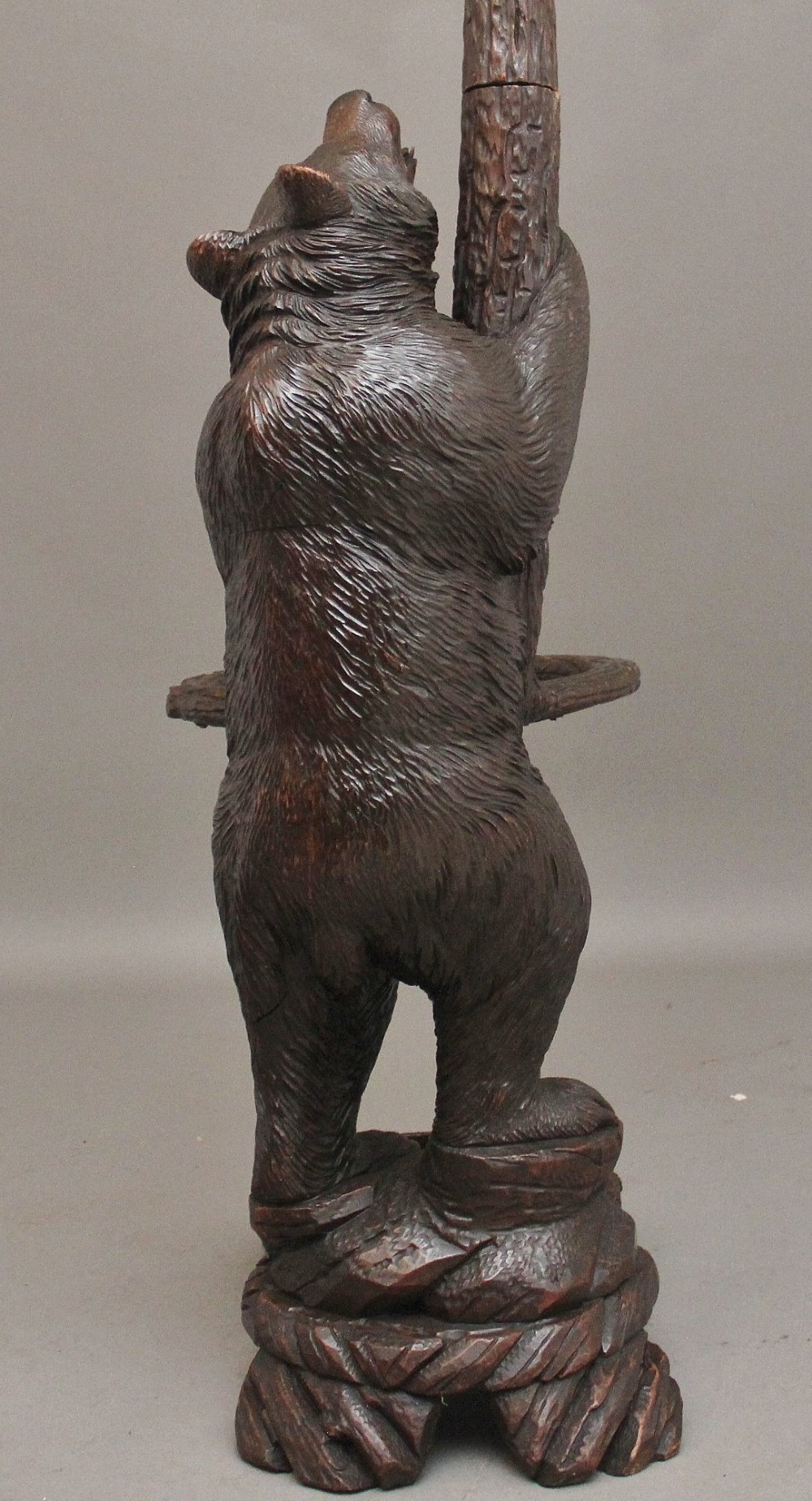 A 19th-century hand-carved Black Forest hall stand featuring two carved bear figures, branch-form coat hooks, small mirrors, and an umbrella ring base. View XIV